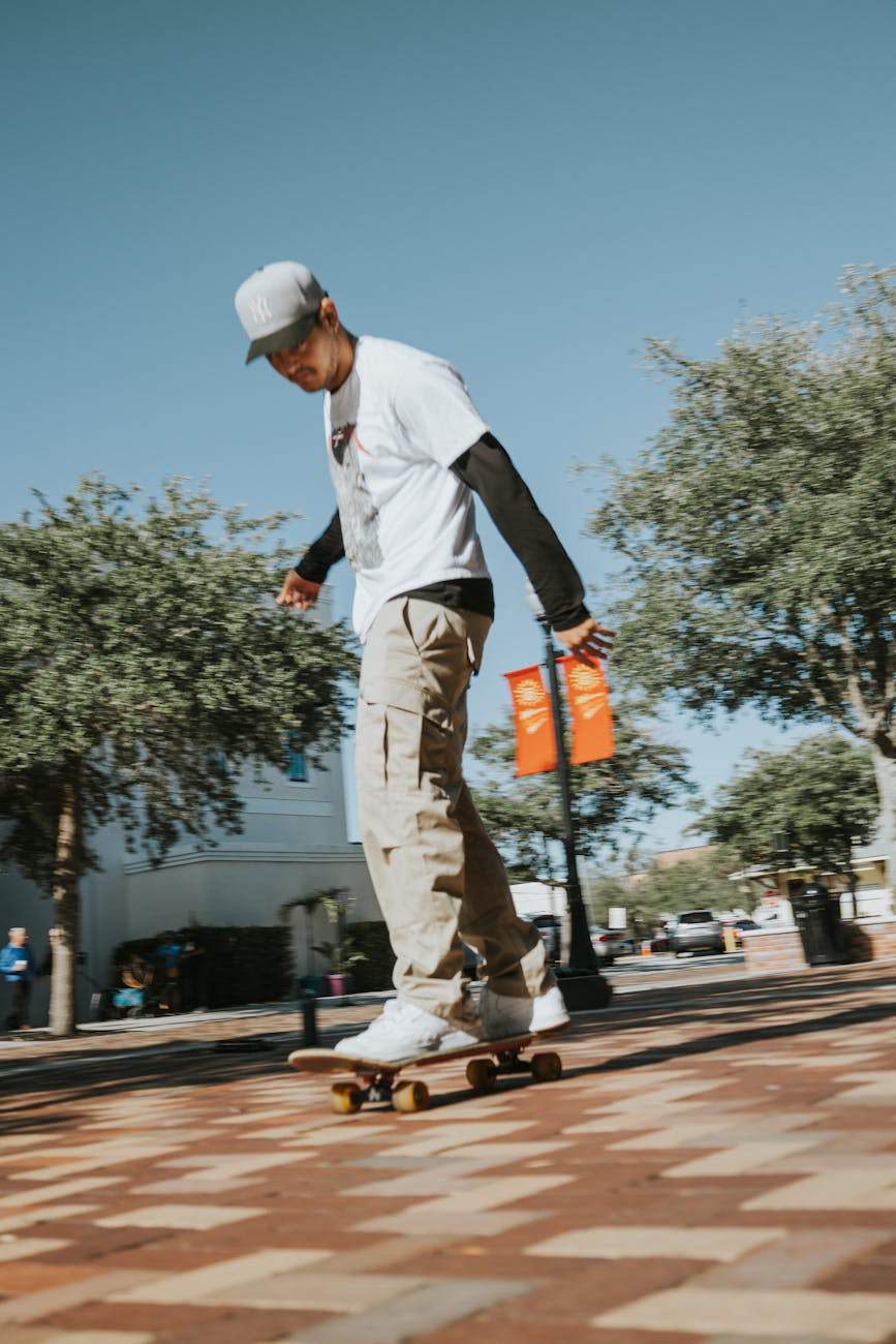 A young man skillfully skateboarding in an urban park during a sunny day.